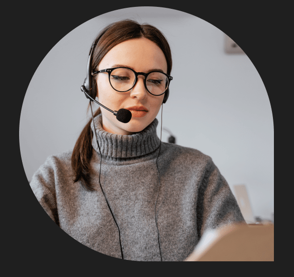 Donna con occhiali che parla in cuffia e utilizza software per call center